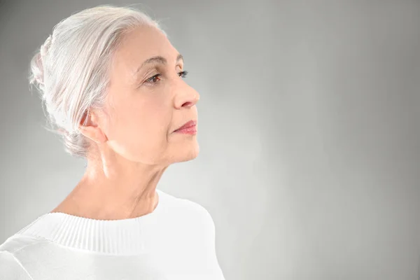 Mulher idosa elegante bonita no fundo cinza — Fotografia de Stock