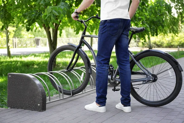 Junger Mann parkt Fahrrad im Freien — Stockfoto