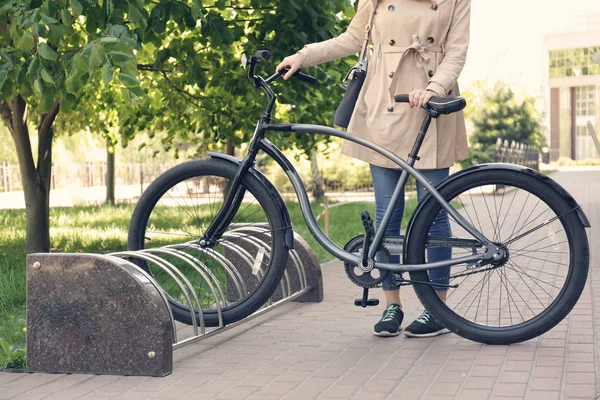Mujer joven estacionamiento bicicleta al aire libre — Foto de Stock