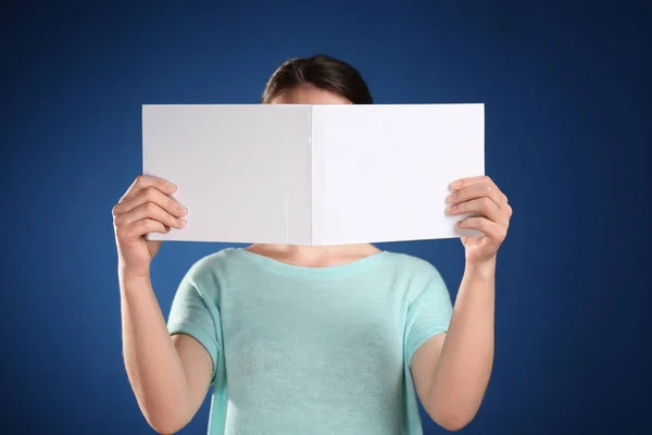 Woman holding open book with blank cover on color background — Stock Photo, Image