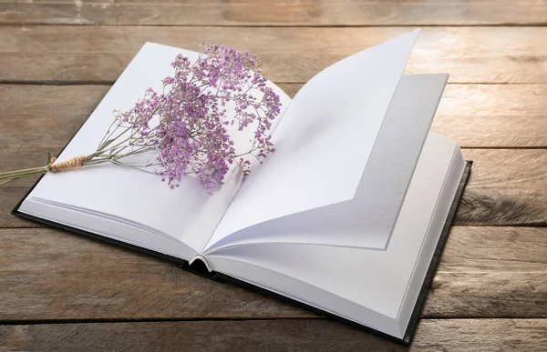 Open book with blank pages and beautiful flowers on wooden background — Stock Photo, Image