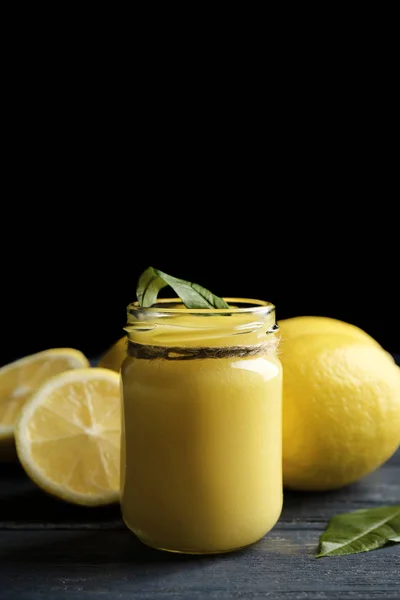 玻璃罐与美味的柠檬酱，木制的桌子上 — 图库照片