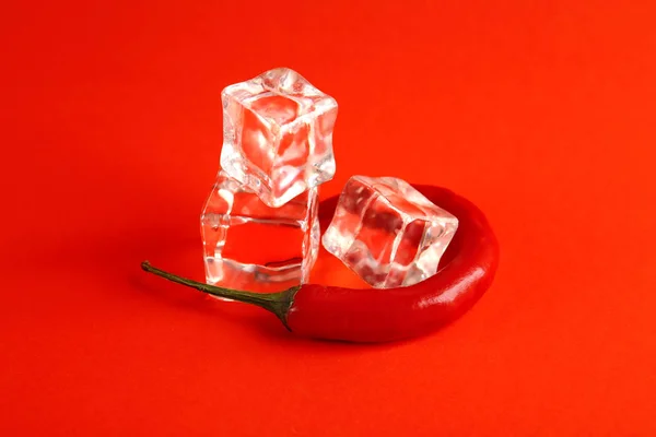 Cubetti di ghiaccio e peperoncino su sfondo di colore. Concetto sessuale — Foto Stock