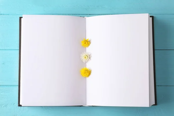 Renk ahşap arka plan, closeup boş sayfalar ve güzel çiçekler ile açık kitap — Stok fotoğraf