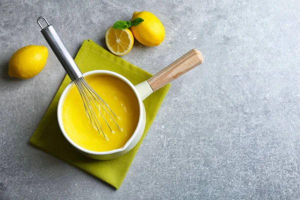 Saus panci dengan dadih lemon yang lezat dan whisk di atas meja — Stok Foto