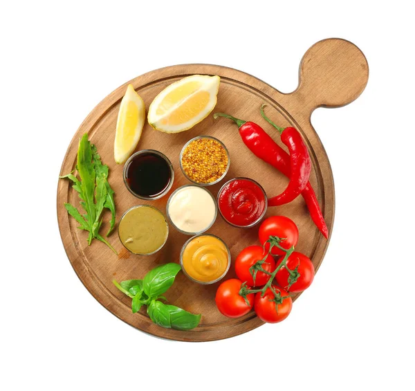 Farklı sos ve beyaz arka plan üzerinde sebze ile ahşap tahta