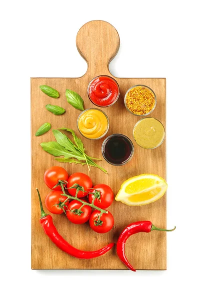 Farklı sos ve beyaz arka plan üzerinde sebze ile ahşap tahta