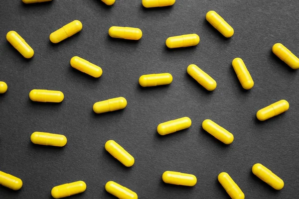 Yellow pills on dark background — Stock Photo, Image