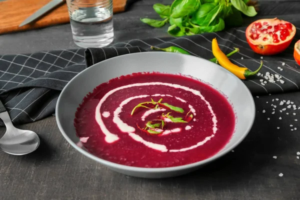 Вкусный свекольный суп со сметаной в миске на кухонном столе — стоковое фото