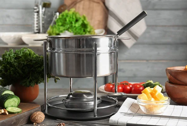 Heerlijke kaasfondue met verschillende hapjes op tafel — Stockfoto