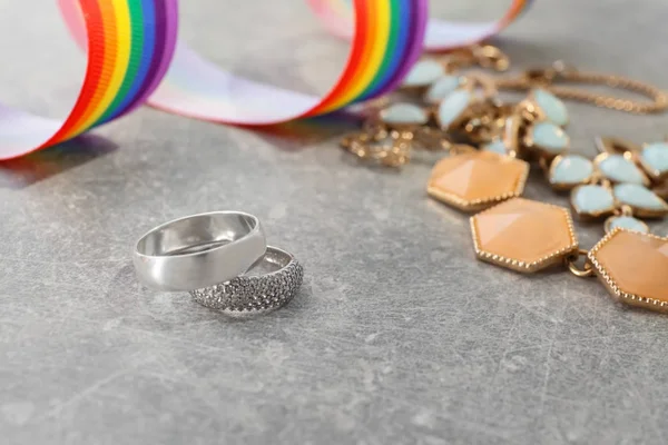 Cincin perak untuk pernikahan lesbian di meja abu-abu — Stok Foto