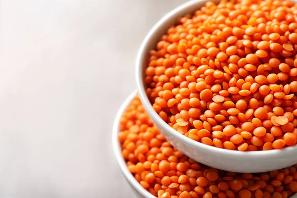 Bowls with red lentils on light background — Stock Photo, Image