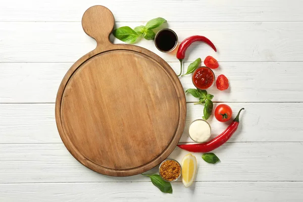 Composición con tabla de madera, diferentes salsas y verduras en la mesa —  Fotos de Stock