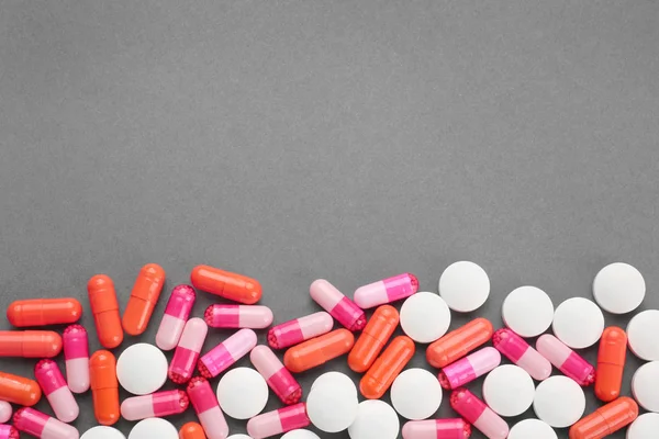 Concept de soins de santé. Pilules colorées sur fond gris — Photo