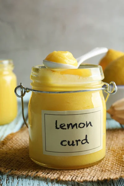 Glass jar with delicious lemon curd on wooden table — Stock Photo, Image