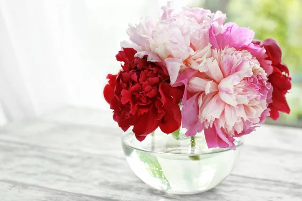 Ваза с красивыми пионскими цветами на столе — стоковое фото