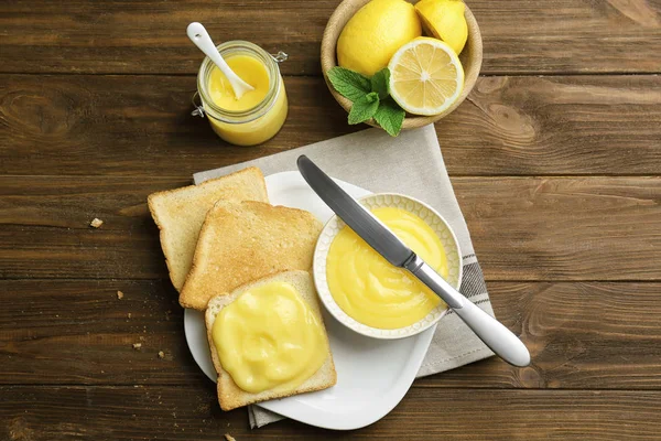 Composition with fresh toasts and delicious lemon curd on wooden table — Stock Photo, Image