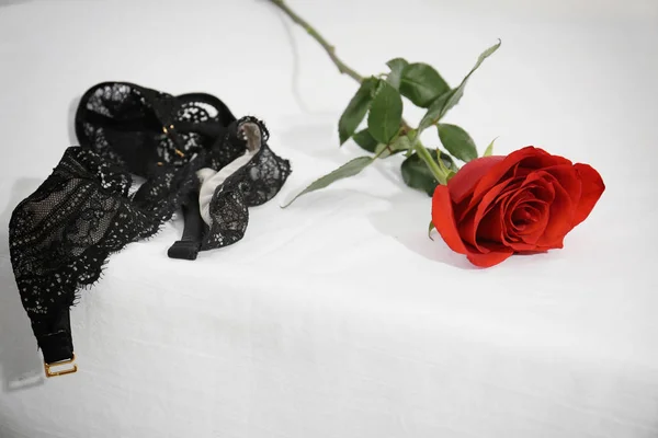 Δαντέλα σουτιέν και τριαντάφυλλο στο κρεβάτι. Έννοια του σεξ — Φωτογραφία Αρχείου