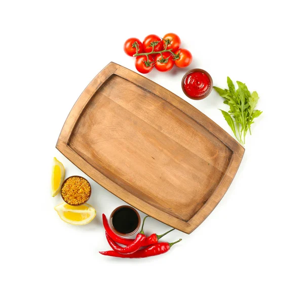 Composition avec assiette en bois et différentes sauces sur fond blanc — Photo