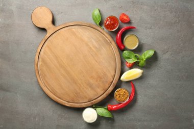 Ahşap tahta, farklı sos ve gri arka plan üzerinde sebze