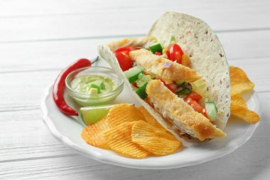 Lezzetli balık taco sos ve patates kızartması Beyaz ahşap zemin üzerinde ile plaka üzerinde