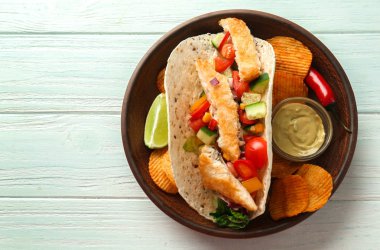 Lezzetli balık taco sos ve patates kızartması Beyaz ahşap zemin üzerinde ile plaka üzerinde