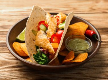 Lezzetli balık taco sos ve ahşap arka plan üzerindeki fişlere plaka üzerinde