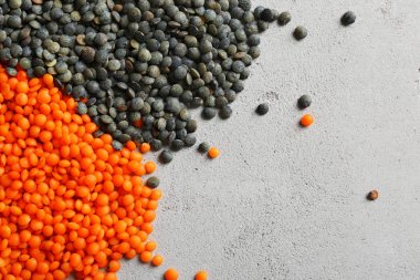 Gri arka plan üzerinde kırmızı ve siyah mercimek, yığınları