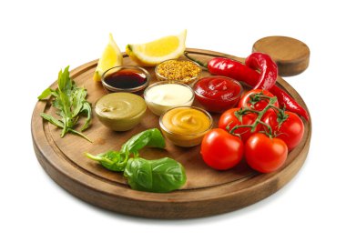 Farklı sos ve beyaz arka plan üzerinde sebze ile ahşap tahta