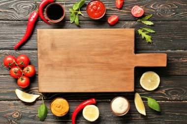 Ahşap tahta, farklı sos ve sebze masada