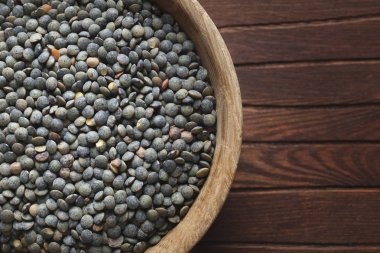 Ahşap arka planda siyah mercimek kasesi