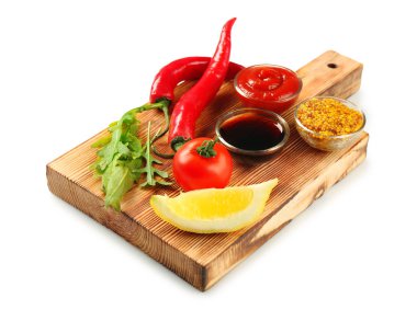 Farklı sos ve beyaz arka plan üzerinde sebze ile ahşap tahta