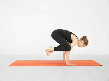Yoga poz beyaz duvar kapalı yakınındaki pratik genç güzel kadın