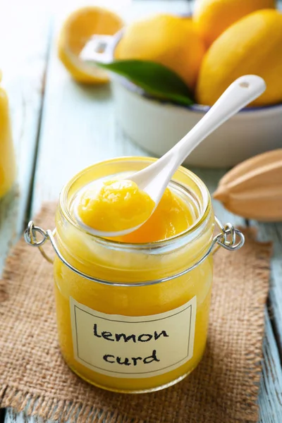 Pot en verre avec une délicieuse caillé de citron sur une table en bois — Photo