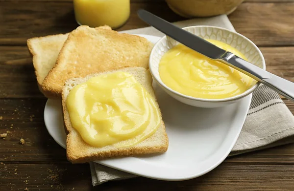 Složení s máslem a lahodné citronový krém na dřevěný stůl — Stock fotografie