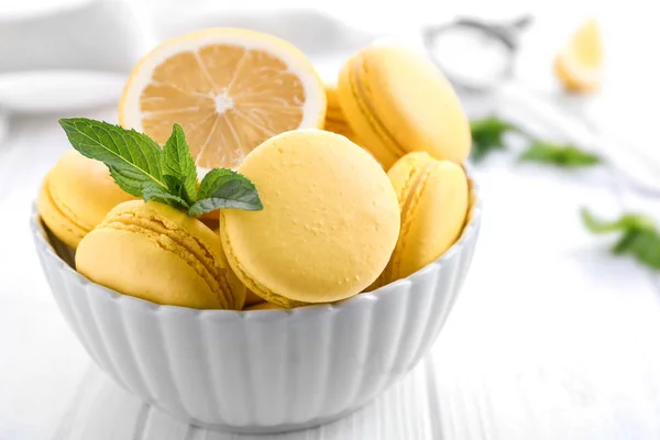 Tigela com saborosos macarons de limão na mesa de madeira branca, close-up — Fotografia de Stock