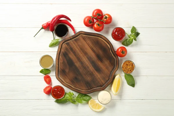 Plateau en bois, différentes sauces et légumes sur la table — Photo