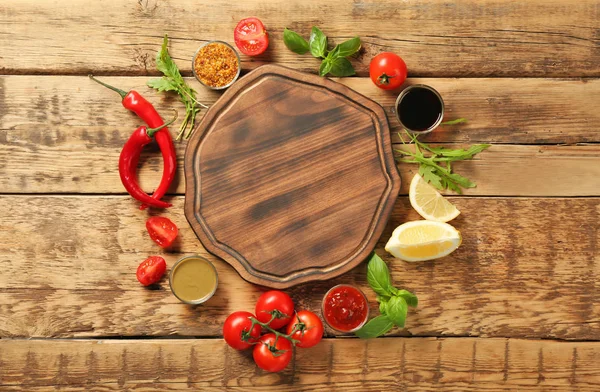 Plateau en bois, différentes sauces et légumes sur la table — Photo