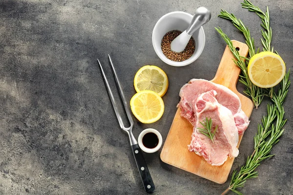 Raw steaks with ingredients on kitchen table — Stock Photo, Image