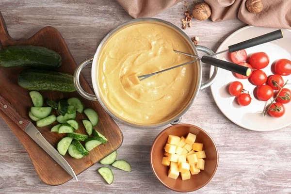 Delicious cheese fondue and vegetables on table — Stock Photo, Image
