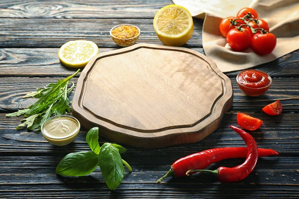 Assiette en bois, différentes sauces et légumes sur la table — Photo