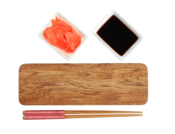 Ahşap tahta, yemek çubukları, soya sosu ve beyaz arka plan üzerinde turşu zencefil — Stok fotoğraf