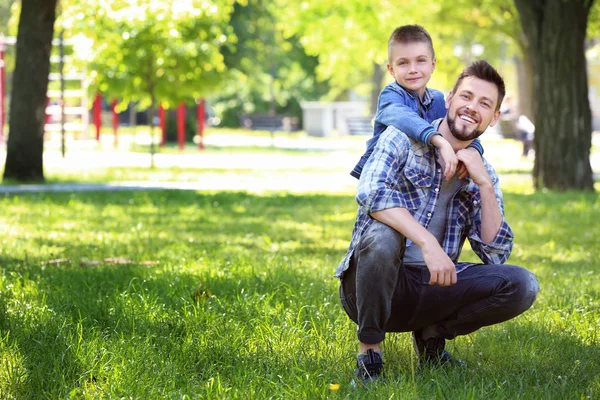 Baba ve oğlu yeşil park güneşli — Stok fotoğraf