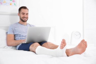 adam laptop ve bandajlı bacak