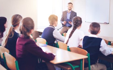 Çocuklar okulda sınıfta öğretmen dinleme