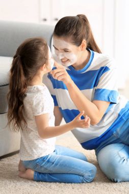 Genç kadın ve küçük kızı ile yüz maskeleri evde