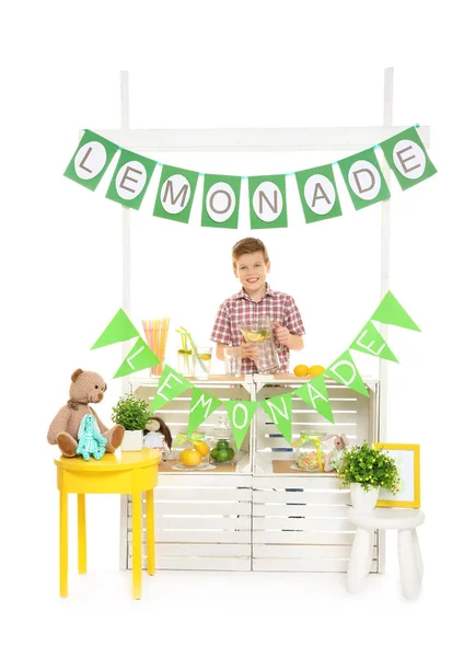 Lindo niño vendiendo limonada en el mostrador sobre fondo blanco — Foto de Stock