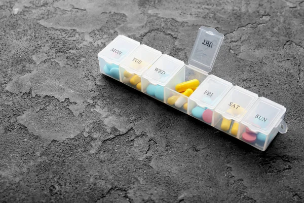 Пластиковый контейнер с различными таблетками — стоковое фото