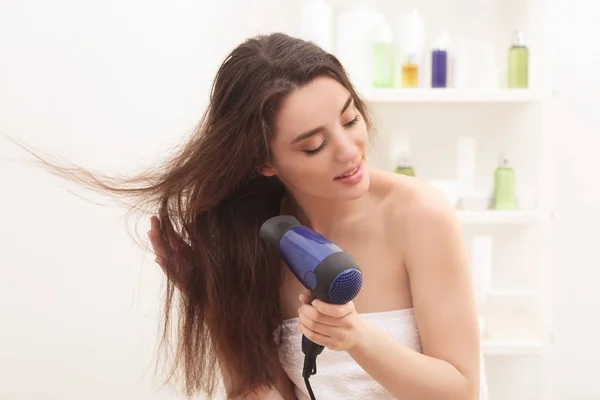 Jovem mulher secando cabelo — Fotografia de Stock