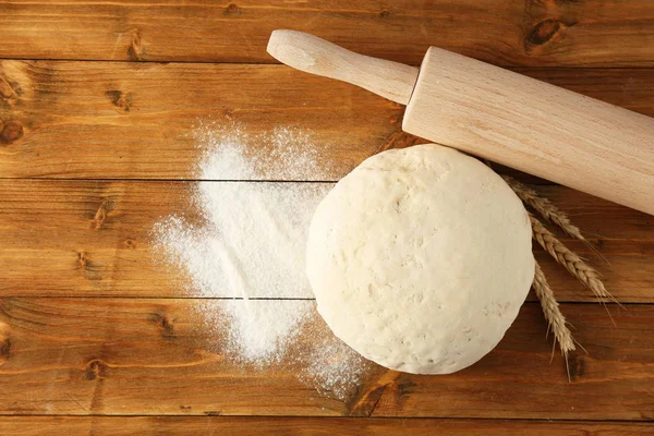 Ball of raw dough, wheat and rolling pin — Stock Photo, Image